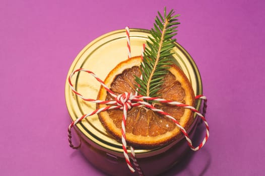 Homemade jam in a decorated jar with orange slice and fir tree twig. handmade Christmas gift