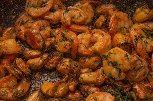 Fried prawns and mussels. grilled seafood close up. cooking process