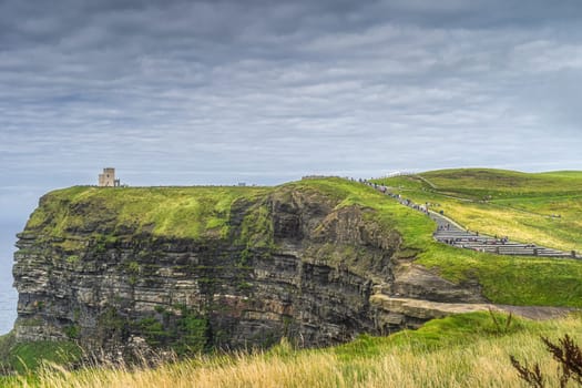 Crowds of tourists walking on stairs to OBriens Tower on iconic Cliffs of Moher, popular tourist attraction, UNESCO, Wild Atlantic Way, Clare, Ireland
