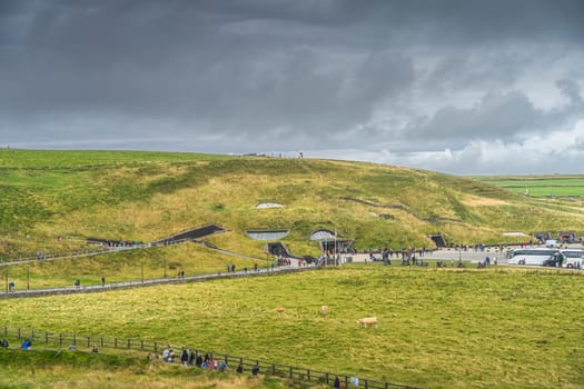 Doolin, Co. Clare, Ireland, August 2019 Crowd of tourists visiting iconic Cliffs of Moher, main visitor centre and car parking full of busses and cars