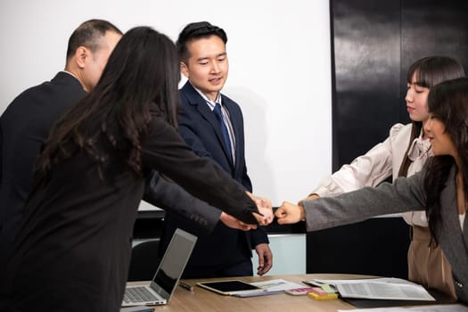 Business people join punching fists bump hands as team their meeting, Giving touch punch together of power teamwork, Business group winning successful company achieving goals with determined staff
