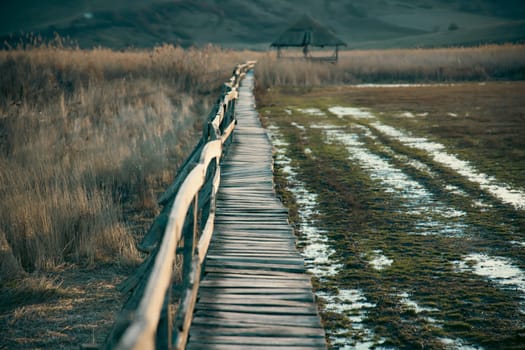 Old wooden boardwalk with a railing on the side and watchtower in the Sic reed reservation, Cluj , Romania