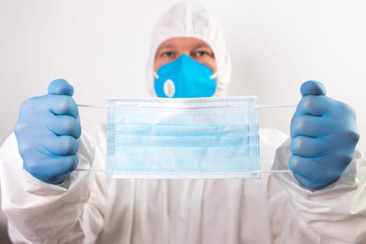 Doctor hand wear blue medical gloves holds antivirus face mask for pandemic diseases. Outbreak, Covid19 concept