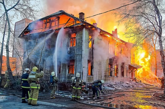 Firefighters extinguish a fire in a two-story wooden house. High quality photo