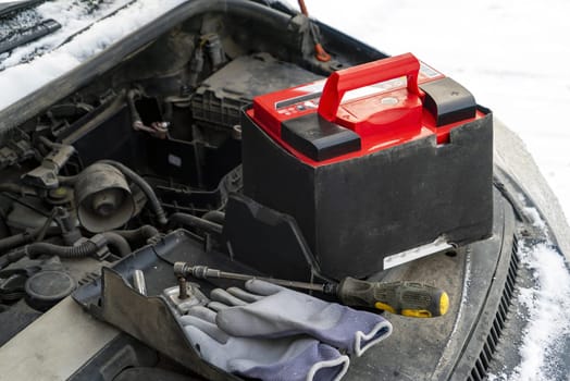 A new battery in the engine compartment of the car in winter