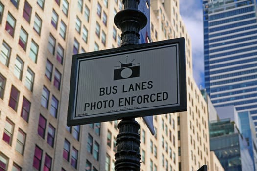 White Bus Lanes Photo Enforced sign hanging on a black pool in downtown Manhattan in New York City
