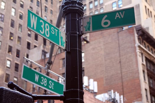 Green West 38th Street and Avenue of the Americas 6th traditional sign in Midtown Manhattan in New York City