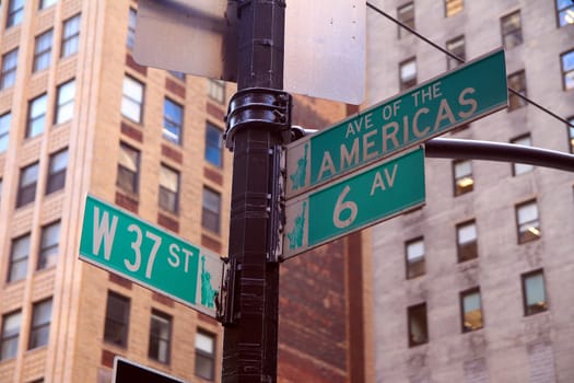 Green West 37th Street and Avenue of the Americas 6th traditional sign in Midtown Manhattan in New York City