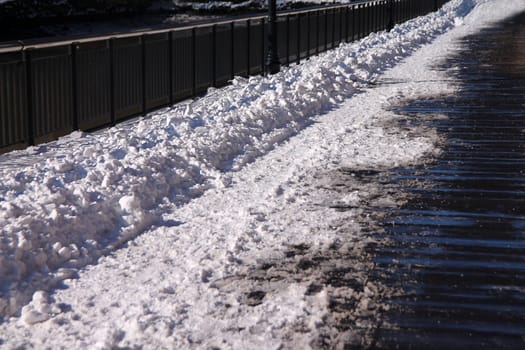 The fresh snow on the wooden walkaway in a sunny winter and cold day