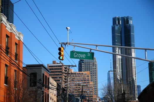 Green big Grove Street sign hanging on a arch pole between traffic lights in the streets of downtown Jersey City