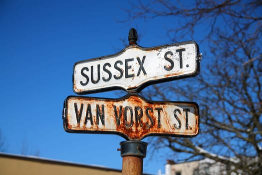 Historical, traditional and rust Sussex Street and Van Vorst Street intersection iron sign in Paulus Hook in Jersey City