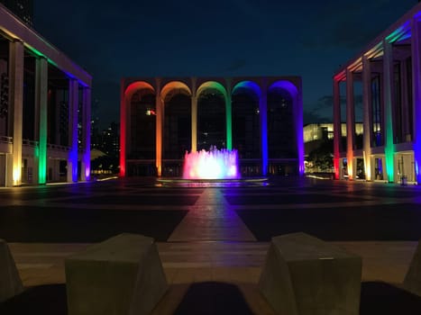 Rainbow colored lights illuminating the colonnade of Lincoln Center in New York City