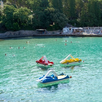 Bathing bay with pedal boats on the coast of the Adriatic Sea near the town of Krk in Croatia