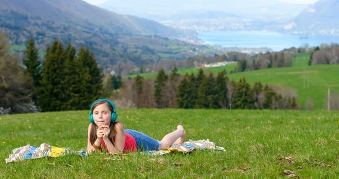 a pretty young girl listening to music in nature