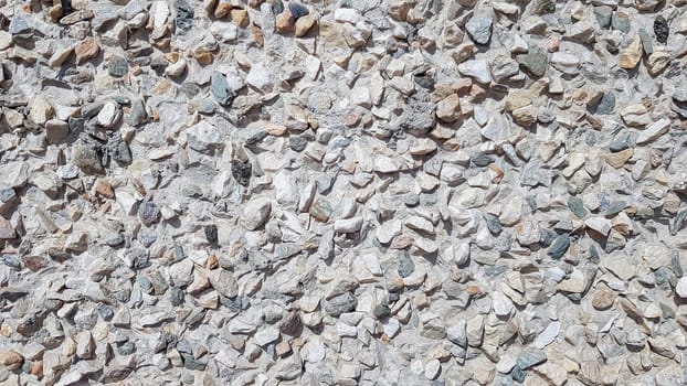 Pebbles Rubble In the cement courtyard. Dirty cracked old grunge vintage light gray concrete and cement mold texture wall or floor background with weathered paint and scratches.