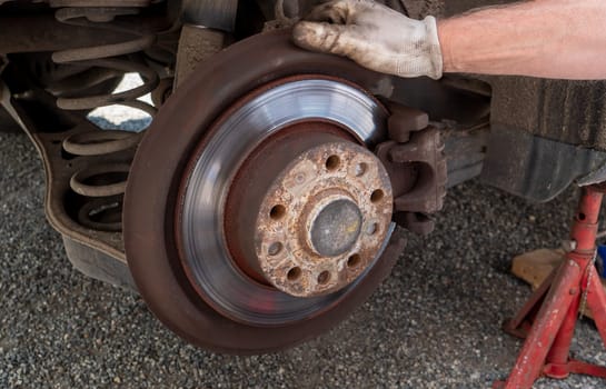 a Car mechanic repairing brakes on car