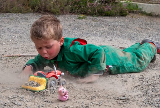 a dirty child playing ground with tractor toy