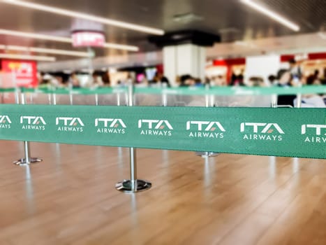 Fiumicino, Italy, Oct 2021: green ribbon barrier with the ITA airways logo inside the Leonardo da Vinci airport in Rome, Italy. ITA Airways is the new Italian flag carrier from 15 October 2021