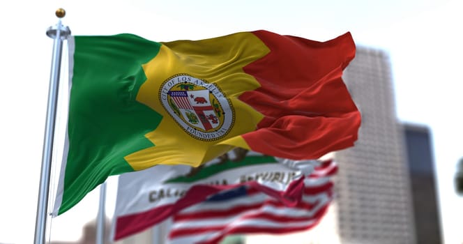Los Angeles city flag waving in the wind with California state and United States national flags blurred in background