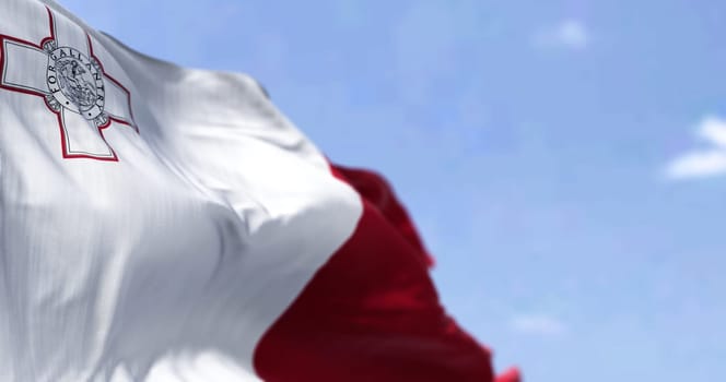 Detail of the national flag of Malta waving in the wind on a clear day. Democracy and politics. Patriotism. Selective focus. Southern European country. Seamless Slow motion