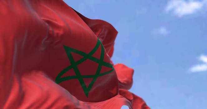 Detail of the national flag of Morocco waving in the wind on a clear day. North African Country. Patriotism. Selective focus.