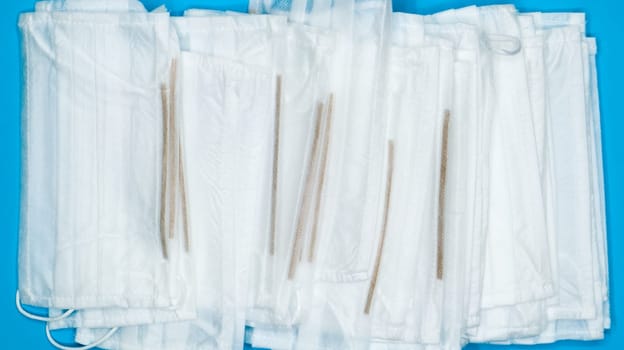 Coronavirus protection. Antiviral protective medical face masks with ear loops. Surgical mask background. Respiratory syndrome, coronavirus disease COVID-19. Many folded medical masks