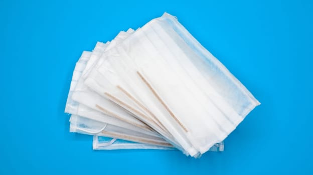 Coronavirus protection. Antiviral protective medical face masks with ear loops. Surgical mask background. Respiratory syndrome, coronavirus disease COVID-19. Many folded medical masks