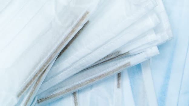 Coronavirus protection. Antiviral protective medical face masks with ear loops. Surgical mask background. Respiratory syndrome, coronavirus disease COVID-19. Many folded medical masks