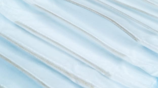 Coronavirus protection. Many antiviral protective medical face masks with ear loops spread out on a blue background. Surgical mask background. Respiratory syndrome, coronavirus disease COVID-19