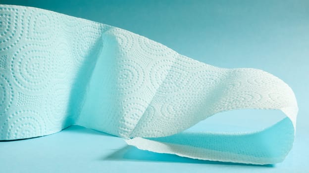 Blue roll of modern toilet paper on a blue background. A paper product on a cardboard sleeve, used for sanitary purposes from cellulose with cutouts for easy tearing. Embossed drawing.