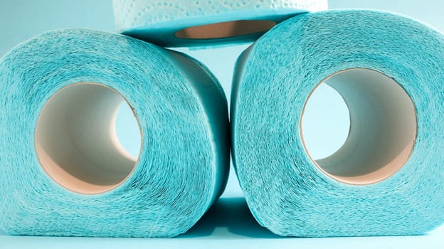 Blue roll of modern toilet paper on a blue background. A paper product on a cardboard sleeve, used for sanitary purposes from cellulose with cutouts for easy tearing. Embossed drawing.