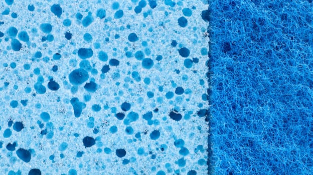 Background in the form of a porous structure in blue. Macro sponge. Close up blue sponge surface for textured background. copy space