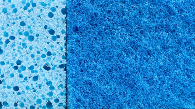 Background in the form of a porous structure in blue. Macro sponge. Close up blue sponge surface for textured background. copy space