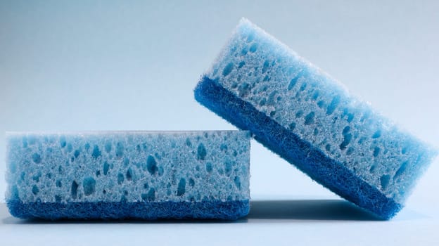 Two blue sponges used for washing and erasing dirt used by housewives in everyday life. They are made of porous material such as foam. Detergent retention, which allows you to spend it economically.