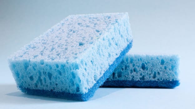 Two blue sponges used for washing and erasing dirt used by housewives in everyday life. They are made of porous material such as foam. Detergent retention, which allows you to spend it economically.