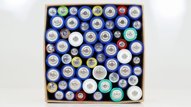 Top view of the background of AAA AA batteries and rechargeable batteries. Choice of batteries. Energy supply and recycling concept. Textures of electric elements packed close together in a box