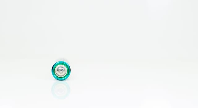One alkaline battery on a white background with reflection. Energy supply and recycling concept. Copy space. Minimalism. Eliment AA is the most common type of galvanic batteries and accumulators