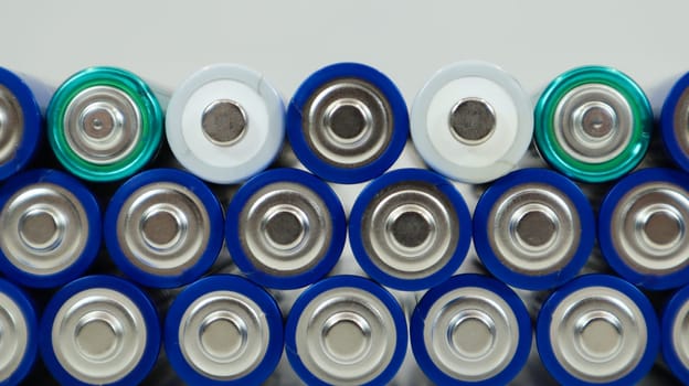 Lots of AA and AAA alkaline batteries on a white background. Ecological recycling concept. The terminals of the disposable batteries are close together and form a beautiful backdrop. Energy source