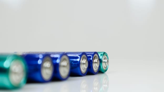 AA alkaline rechargeable batteries on white glossy background with reflection with copy space