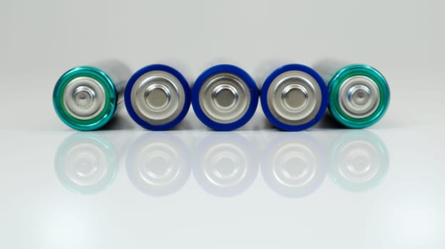 AA alkaline rechargeable batteries on white glossy background with reflection with copy space