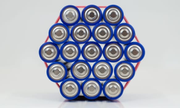 Lots of AA and AAA alkaline batteries on a white background. Ecological recycling concept. The terminals of the disposable batteries are close together and form a beautiful backdrop. Energy source