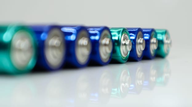 AA alkaline rechargeable batteries on white glossy background with reflection with copy space
