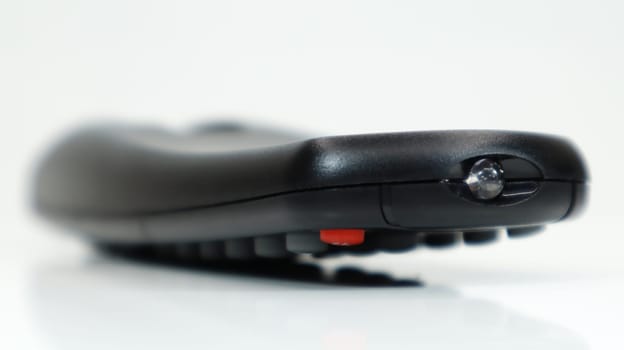 Remote control close-up. Black TV remote control with AAA alkaline batteries on a white background. Battery replacement, spare parts