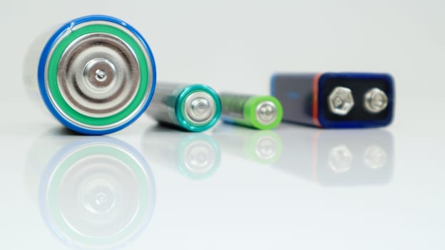Battery type D or C, PP3, AA, AAA on a white background with reflection. View of metal alkaline batteries with copy space. Mandatory processing