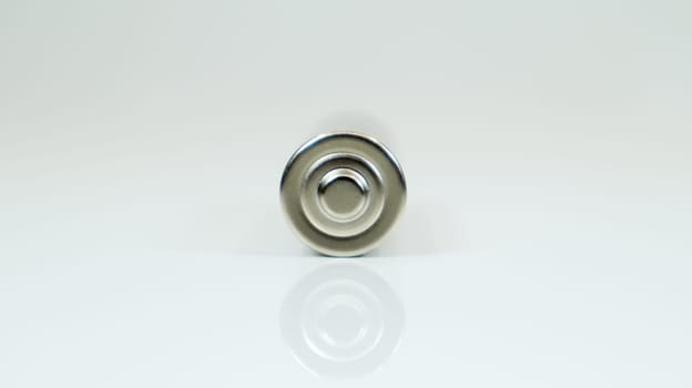 AA alkaline rechargeable battery on white glossy background with reflection. Close one empty battery with copy space
