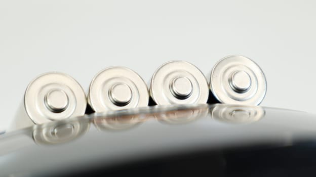 Rechargeable alkaline batteries in a battery charger on a white background. AA fast charger in black. The battery is charging