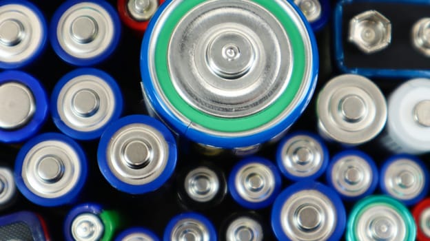 Lots of used household alkaline batteries type AA, AAA, PP3, D, C, collected for recycling. Recycling and ecology problems. Top view of a background of used batteries of different types and sizes