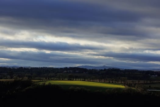 Landscape with green field and clouds