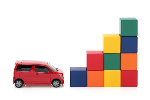 Small toy car and wooden colorful building blocks on white background