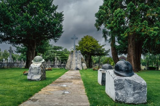 Dublin, Ireland, Aug 2019 Irish infantry helmets with Celtic Cross as a memorial of fallen soldiers who fought in both World Wars, Glasnevin Cemetery